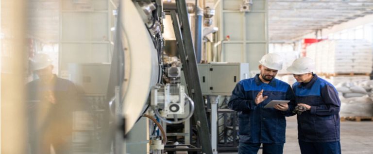 funcionários de macacão azul e capacete branco utilizam o big data na indústria 4.0