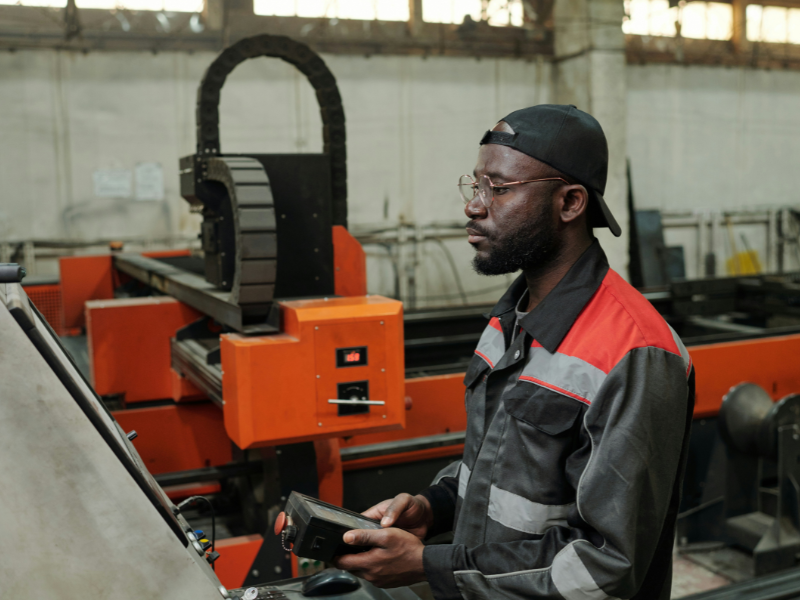 A imagem retrata um trabalhador focado e engajado, operando uma máquina em um ambiente industrial.
