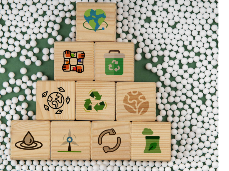 A imagem mostra um conjunto de blocos de madeira dispostos em forma de pirâmide, com símbolos de sustentabilidade em cada um.