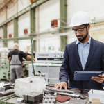 A imagem mostra o interior de uma indústria metalmecânica, com um ambiente amplo e iluminado, repleto de máquinas e equipamentos de usinagem.