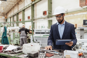 A imagem mostra o interior de uma indústria metalmecânica, com um ambiente amplo e iluminado, repleto de máquinas e equipamentos de usinagem.