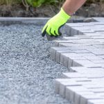 Trabalhador construindo um novo pavimento entrelaçado a partir de pavimentação de concreto, um novo conceito de construção de caminho