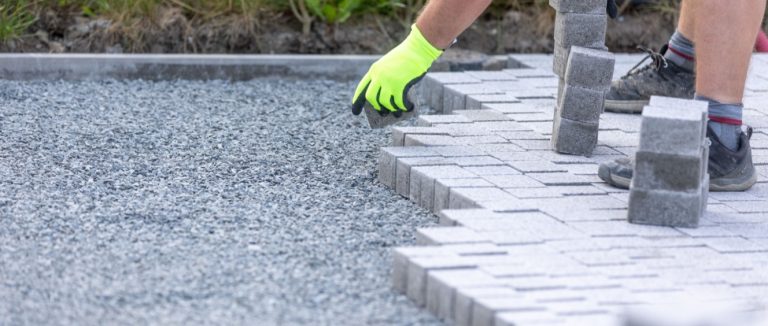 Trabalhador construindo um novo pavimento entrelaçado a partir de pavimentação de concreto, um novo conceito de construção de caminho