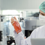 Esta imagem mostra um profissional realizando o controle de qualidade em um ambiente de produção limpo e controlado.