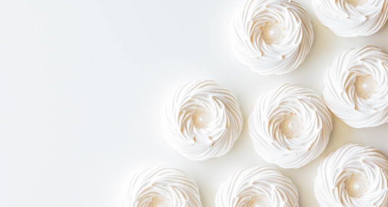 Suspiros em fundo branco ilustram um exemplo de alimentos industrializados que têm em sua composição o dióxido de titânio como corante branco