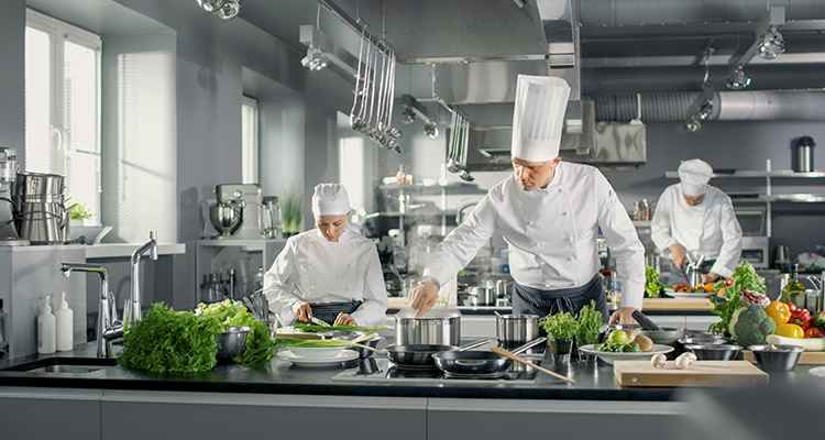 Cálculo de ingredientes: chefs em uma cozinha industrial.