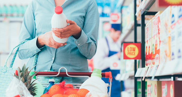 Regulamento técnico do Mercosul sobre rotulagem de alimentos: mulher verificando o rótulo da embalagem de um leite no supermercado.