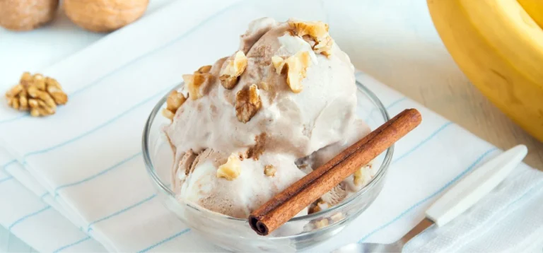 Deliciosa sobremesa de sorvete com nozes e canela, servido em uma taça de vidro. Ideal para aproveitar em dias quentes, acompanhado de banana.