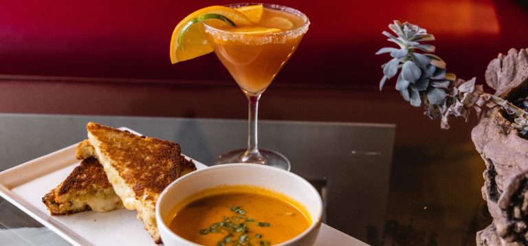 Refeição deliciosa com pão de queijo, sopa cremosa e drink com pedaços de limão, ilustrando a técnica de food pairing.