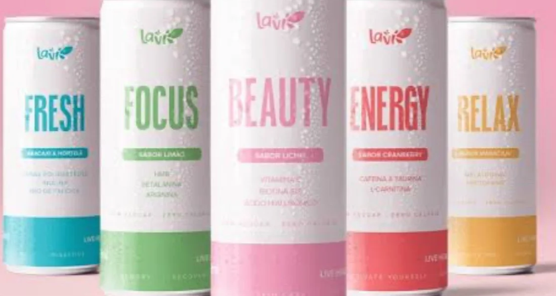 A imagem mostra cinco latas de bebidas funcionais da marca Lavi, cada uma com um nome e função específicos, além de sabores e ingredientes voltados ao bem-estar e saúde. O fundo rosa claro e o design minimalista das latas transmitem um visual moderno, clean e saudável.