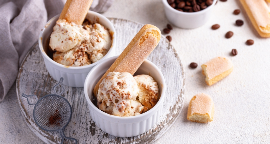 A imagem mostra duas porções de sorvete de tiramisù servidas em pequenos ramequins brancos, com um visual elegante e convidativo.