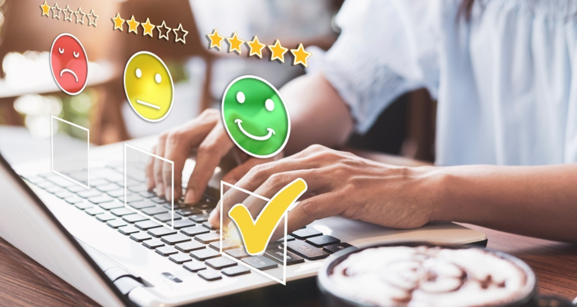 Pessoa avaliando serviço em laptop com ícones de satisfação sobrepostos; o rosto verde sorridente está selecionado, representando uma avaliação positiva e alta satisfação do cliente.