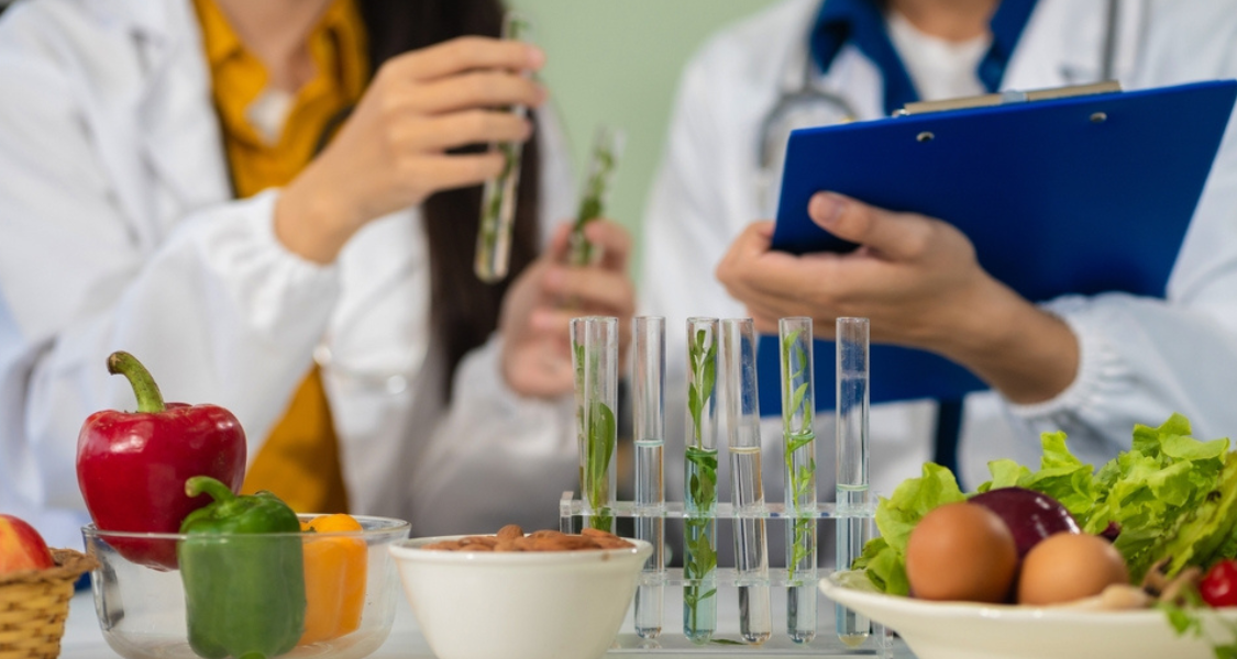 A imagem retrata uma cena de laboratório ou pesquisa científica, focada na interseção entre ciência, nutrição e análise biológica, sugerindo o campo da Nutrição de Precisão ou ciência alimentar.