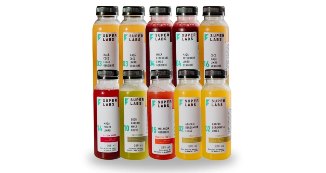 A imagem mostra um mockup ou apresentação de um conjunto de dez garrafas de suco funcional da marca SUPERLABS, organizadas em duas linhas horizontais contra um fundo branco.