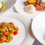 imagem apresenta a etapa final da jornada gastronômica: o prato servido com excelência técnica e estética em um ambiente de alta gastronomia.