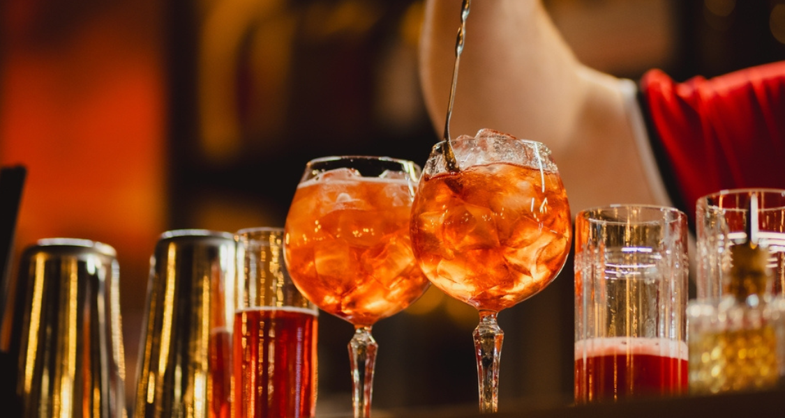 imagem captura a arte da mixologia, representando o serviço de bebidas em um ambiente de bar sofisticado e vibrante.