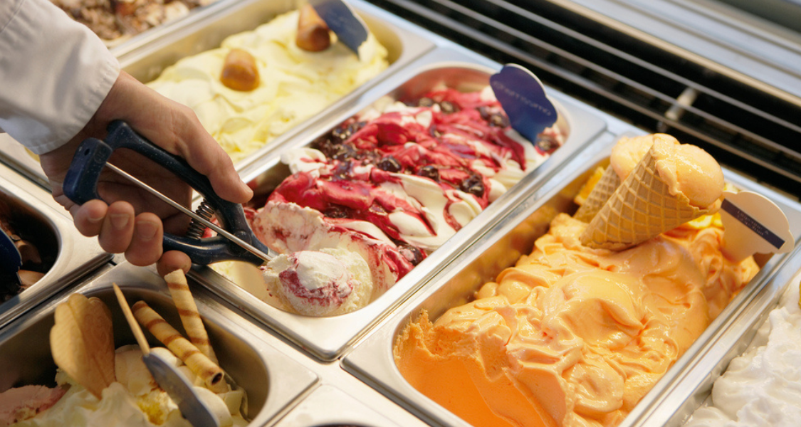 sabores de sorvete variados e um indivíduo se servindo como self-service