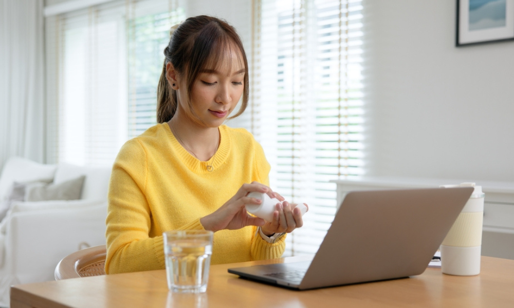 Esta imagem retrata uma cena cotidiana que une autocuidado e rotina de trabalho ou estudos em um ambiente doméstico.