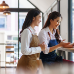 Esta imagem retrata uma cena colaborativa e positiva em um ambiente comercial, provavelmente um café ou restaurante moderno.