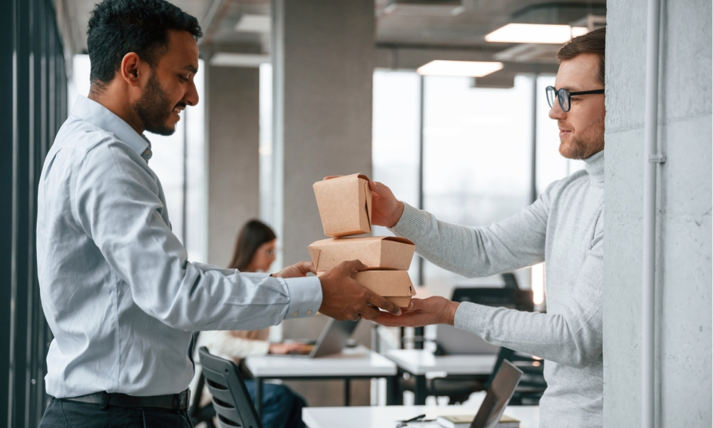 Dois colegas de trabalho em um escritório moderno dividindo a encomenda.