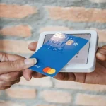 cliente que sabe as vantagens dos cartões private label para o varejo aproxima cartão azul de máquina