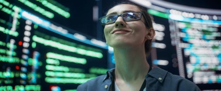 especialista em cibersegurança olhando para cima e com telas com numeros atrás