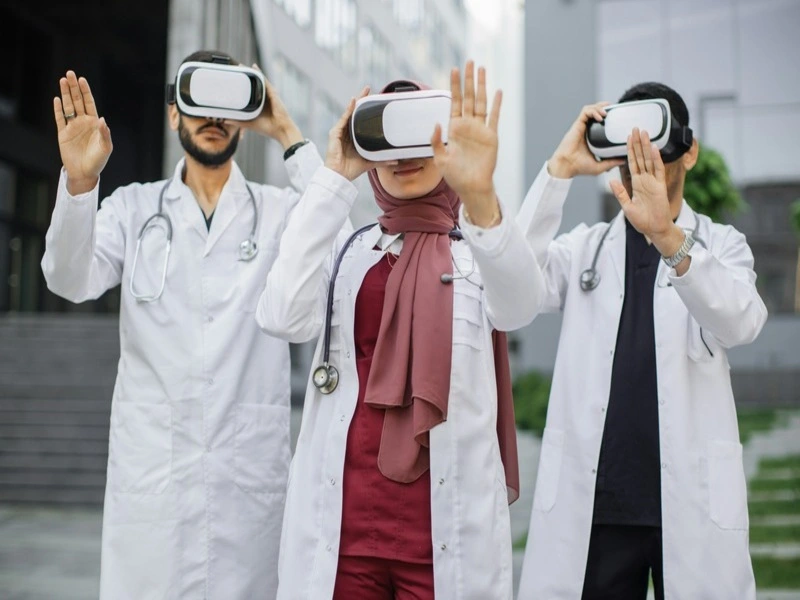 três médicos de jaleco branco usando óculos de VR após o futuro das redes móveis chegar na medicina