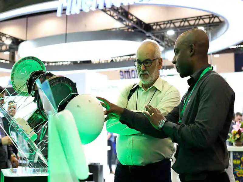 visitantes do conectividade rural no futurecom 2025 analisando um aparelho tecnológico