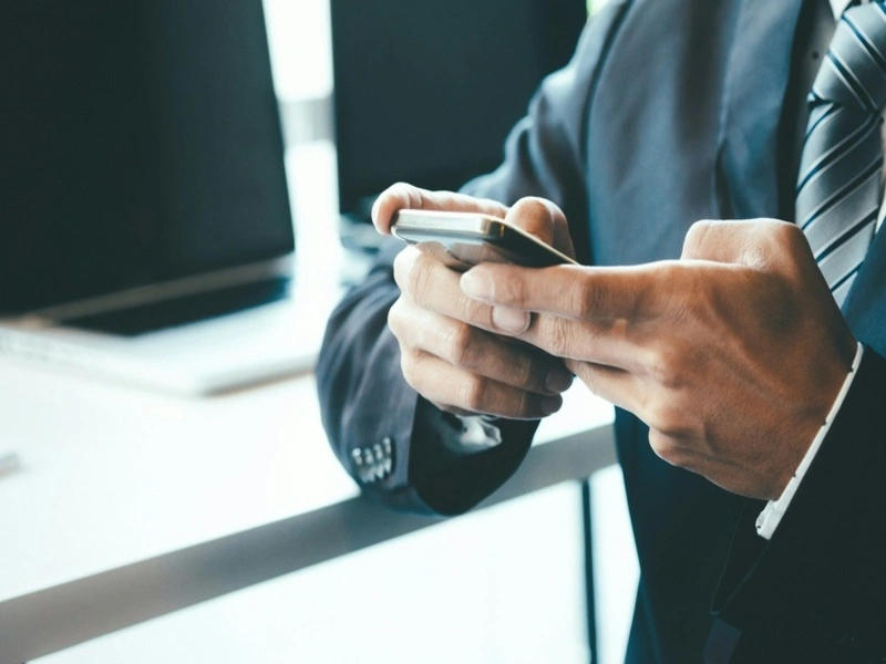 homem de terno usando um celular com uma das maiores operadoras no brasil