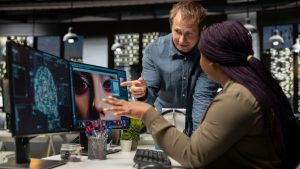 Equipe de retoque multiétnico usando redes neurais para editar conteúdo, aprendizado de máquina e edição de novos materiais fotográficos on-line. Designers profissionais que usam software digital e IA.