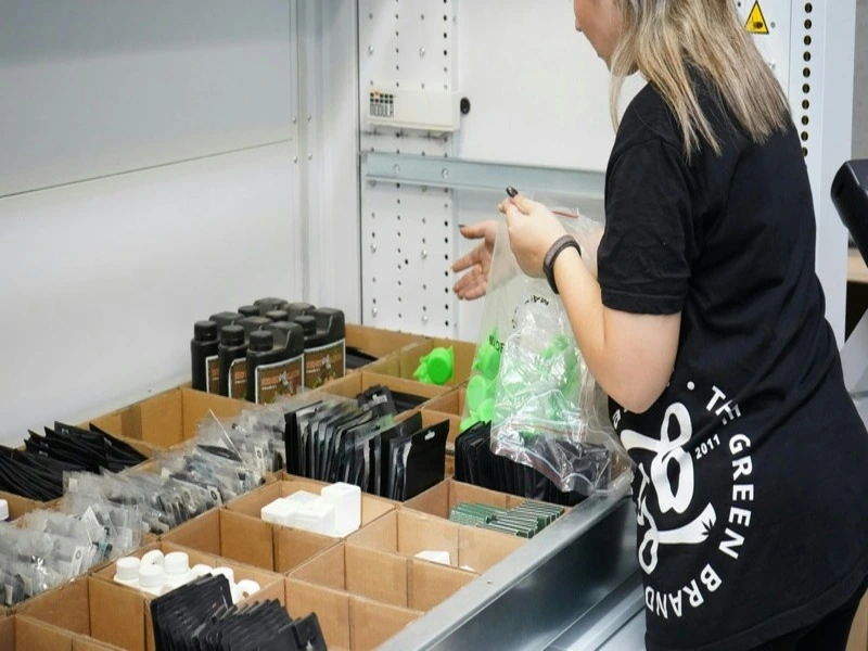 mulher de camisa preta preparando a entrega no e-commerce e embalando os produtos