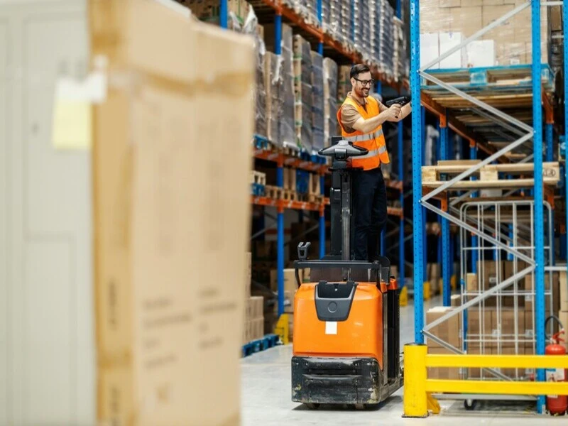 funcionário de logística fazendo a acuracidade de estoque em cima de um aparelho