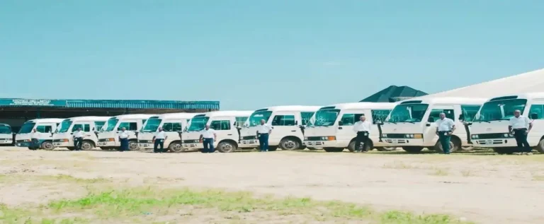 funcionários de sistema intermodal de transporte com caminhões brancos estacionados lado a lado