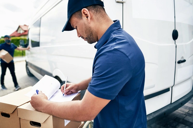 funcionário de logística analisa documentos para carga em transporte rodoviário