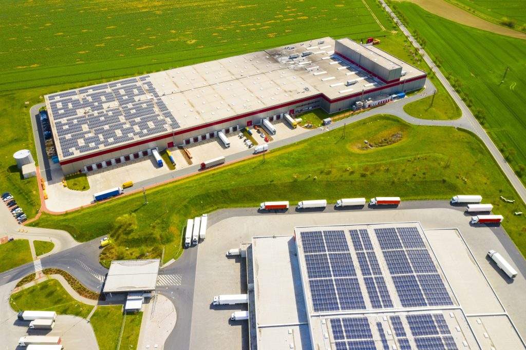 Indústria com baixa pegada de carbono. Galpões industriais com painéis solares no telhado. Parque tecnológico e fábricas vistos de cima.