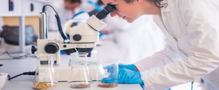 funcionária com jaleco e luvas analisa o estetoscópio e sabe o que são biopolímeros