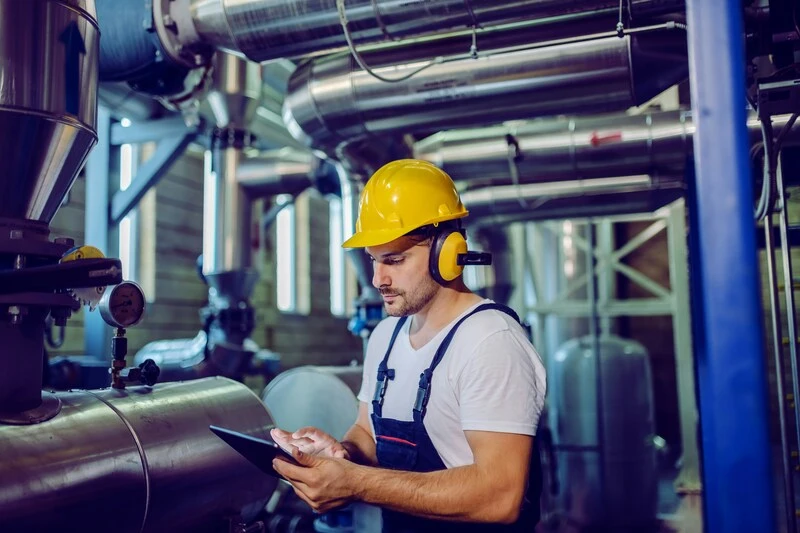trabalhador com tablet e EPIs porque entender os impactos da tecnologia na saúde do trabalhador