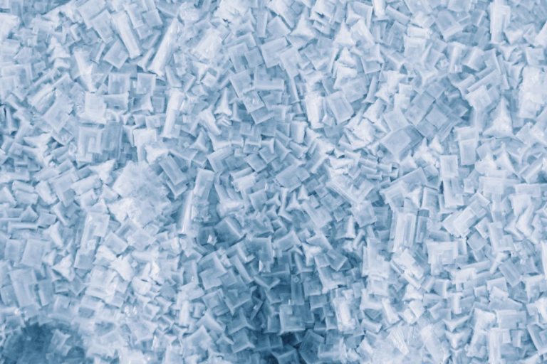 a imagem mostra grânulos ou pellets de resina plástica, provavelmente reciclada.