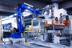 A imagem apresenta uma célula de trabalho robótica automatizada em um ambiente de produção industrial, provavelmente uma fábrica moderna.