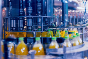 ⚙️ Descrição da Imagem A imagem captura um momento na linha de envase e produção de bebidas em uma fábrica industrial, destacando o processo de enchimento e tamponamento.