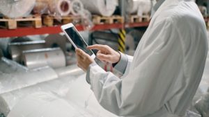 funcionário lê sobre o faturamento da indústria do plástico em 2026 pelo tablet