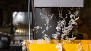 Resíduo plástico saindo da lavadora da linha de reciclagem