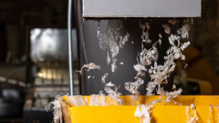 Resíduo plástico saindo da lavadora da linha de reciclagem