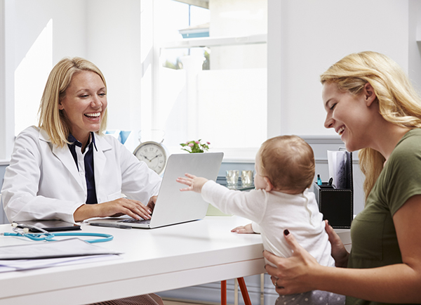 Mother And Baby Meeting With Female Doctor In Office