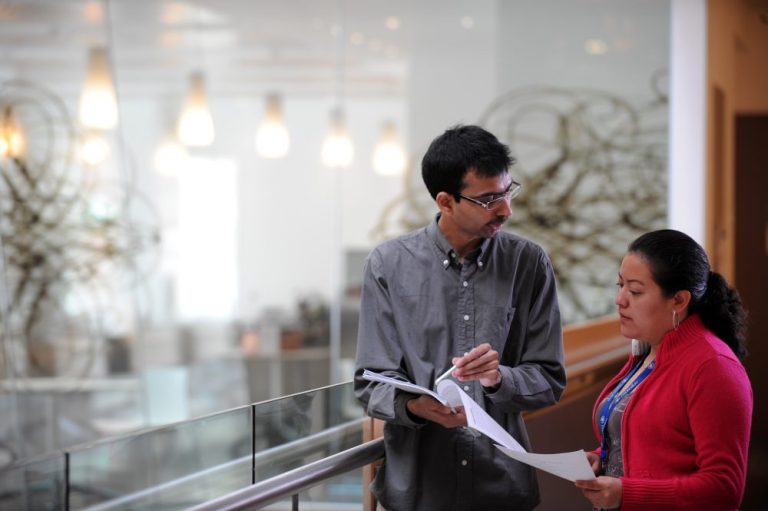 Two people looking at a report at Oxford University[AMBER]