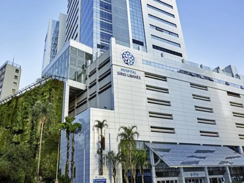 Imagem do Hospital Sírio-Libanês, um renomado hospital localizado na cidade de São Paulo, com construção moderna e destaque para sua fachada com vidro e logo.