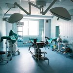 Imagem de uma sala de cirurgia moderna e equipada com mesa cirúrgica, iluminação avançada, equipamentos médicos, e ambiente limpo e organizado, pronto para procedimentos cirúrgicos. A imagem reflete o tema sobre hospitais do mercado livre de energia.