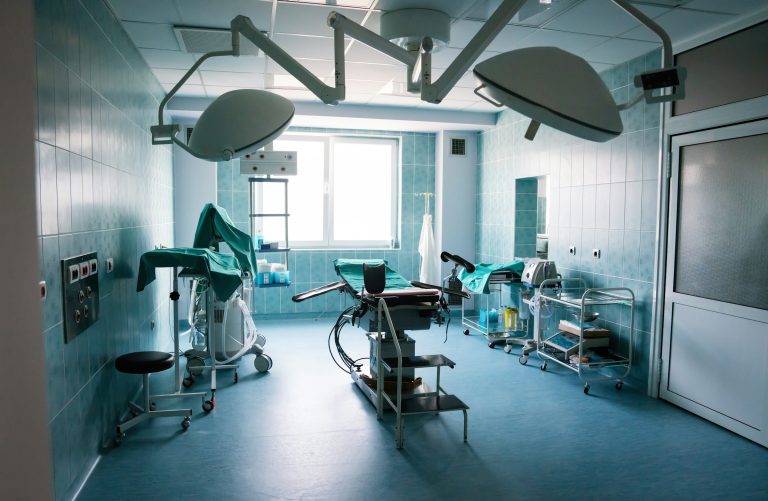 Imagem de uma sala de cirurgia moderna e equipada com mesa cirúrgica, iluminação avançada, equipamentos médicos, e ambiente limpo e organizado, pronto para procedimentos cirúrgicos. A imagem reflete o tema sobre hospitais do mercado livre de energia.