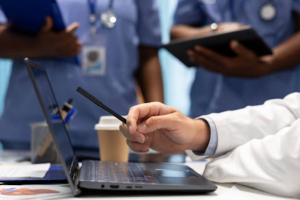 A imagem foca em um ambiente de saúde, como um hospital ou clínica, mostrando a colaboração entre profissionais.