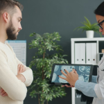 Médica e paciente conversando em ambiente hospitalar e tecnológico.